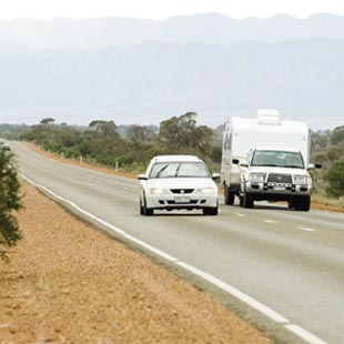 slow moving vehicles and heavy vehicles, car and caravan on country road