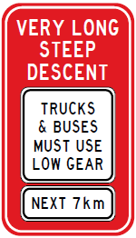 Street sign: Very long steep descent - Trucks and buses must use low gear - Next 7km